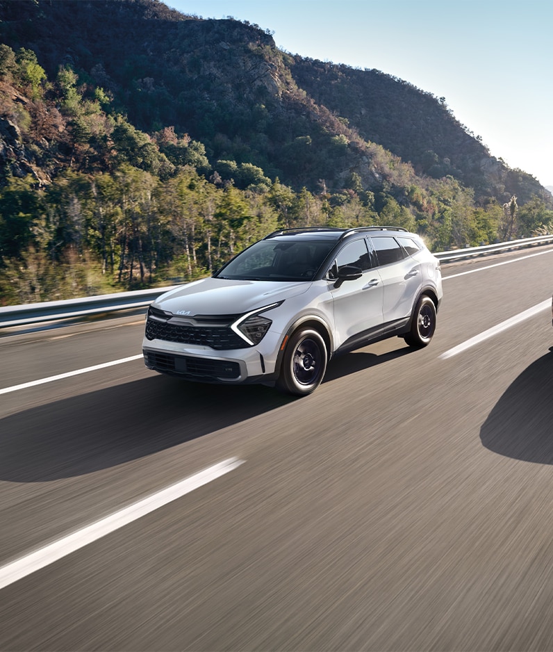 Why drivers should consider an extended warranty on their Kia at West Broad Kia | 2023 Kia Sportage driving down the road on a nice sunny day