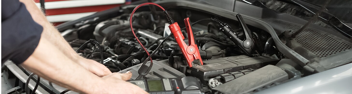 How to Get Your Car Summer Ready at West Broad Kia in Henrico, VA | Person connecting battery cables to car battery so it can start up