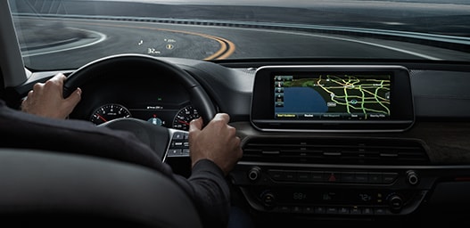Compare the 2021 Kia Telluride vs. the 2021 Honda Pilot at West Broad Kia | Guy driving with dash board navigation
