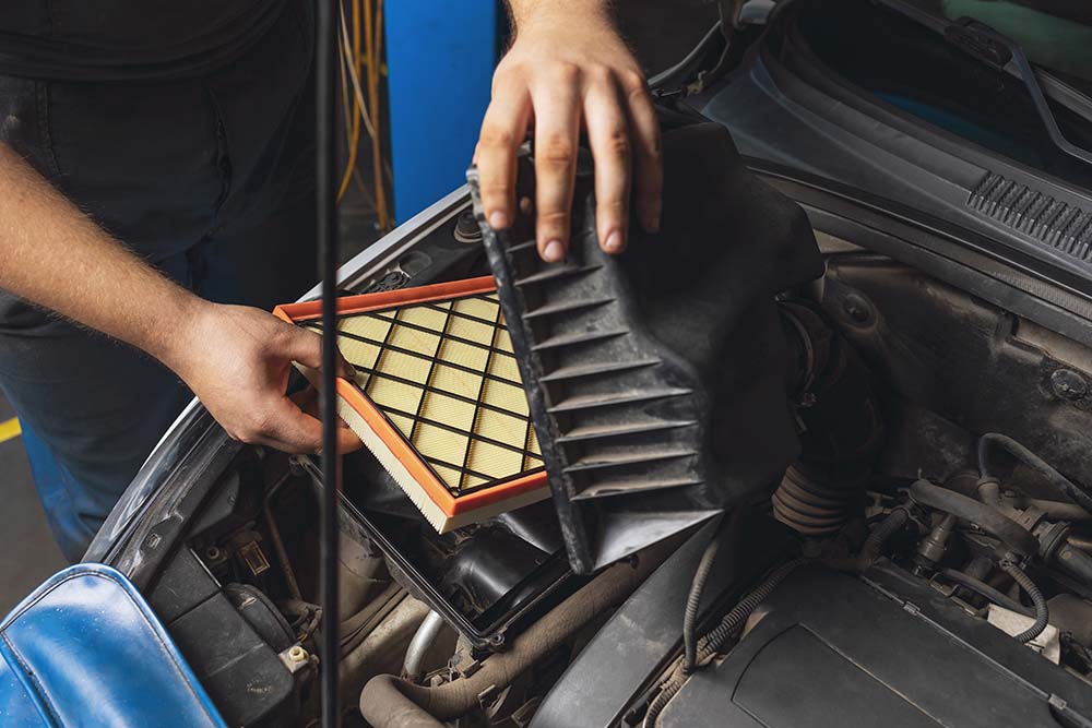 Cabin air filter replacement at West Broad Kia | Kia service technician replacing air filter in vehicle