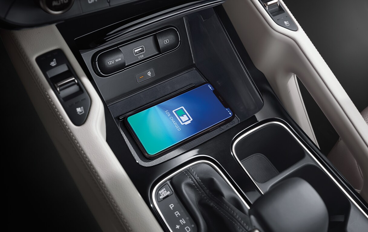 Android Auto vs. Apple CarPlay at West Broad Kia in Henrico, VA | Wireless car charger under the center console of a Kia Telluride