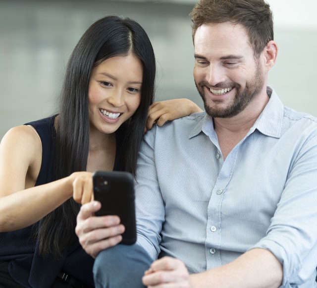 Accessories that help keep your Kia protected at West Broad Kia in Richmond, VA | Customers Looking at Cellphone Together