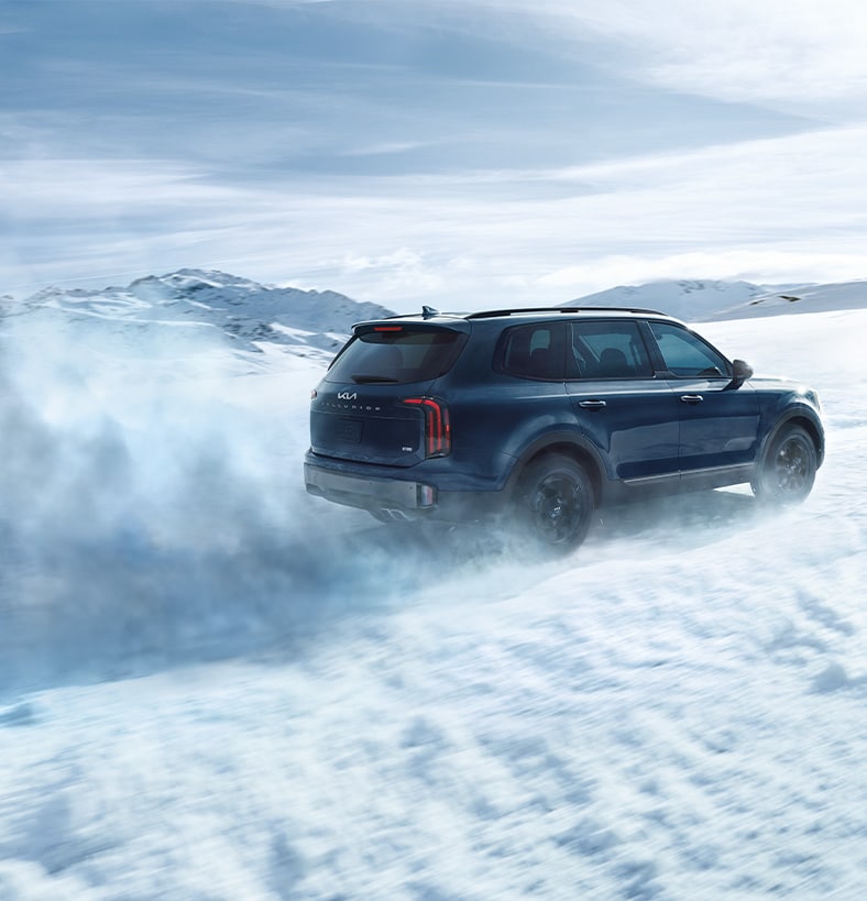The Cold Facts of Winter Tires | West Broad Kia in Henrico, VA | Side profile of a Kia Telluride driving on the snow with snow tires 