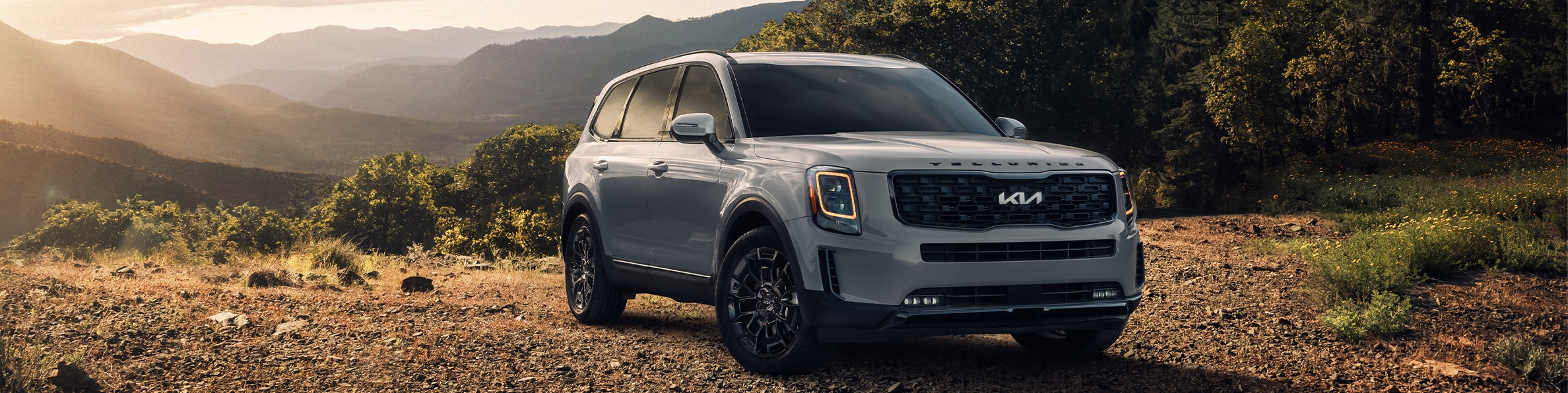 2023 Kia Telluride at West Broad Kia in Henrico, VA | Front view of a 2023 Kia Telluride parked in the middle of a camp site with mountains in the background 