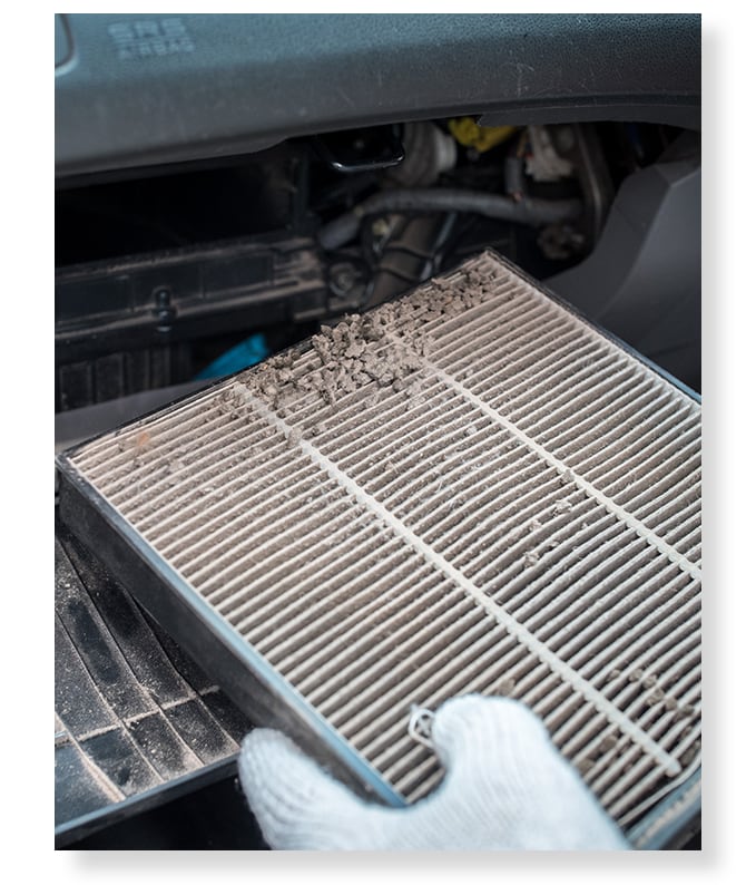 Everything You Need to Know About Cabin Air Filters | West Broad Kia | Dirty cabin air filter being pulled out of car cabin 