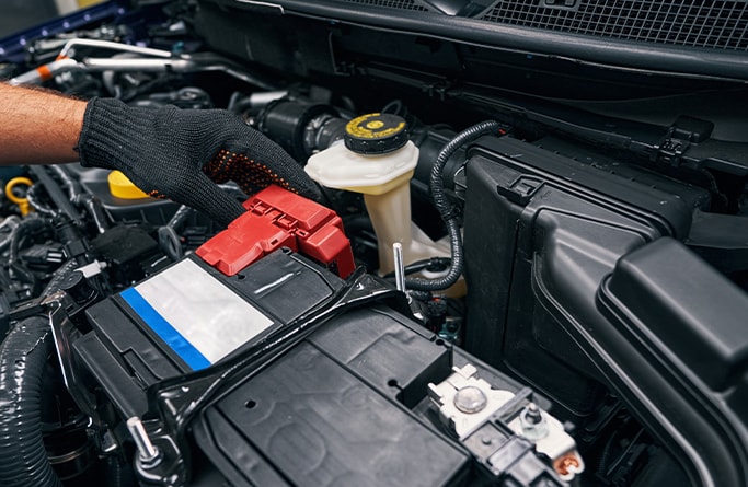 How to Get Your Car Summer Ready at West Broad VW in Richmond, VA | Person with black gloves examining battery in the engine bay  