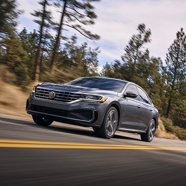 Things to Check When Buying a Used Car | West Broad Volkswagen in Richmond, VA | 2021 Volkswagen Passat Facing Left Driving Fast on Road Through Wooded Area