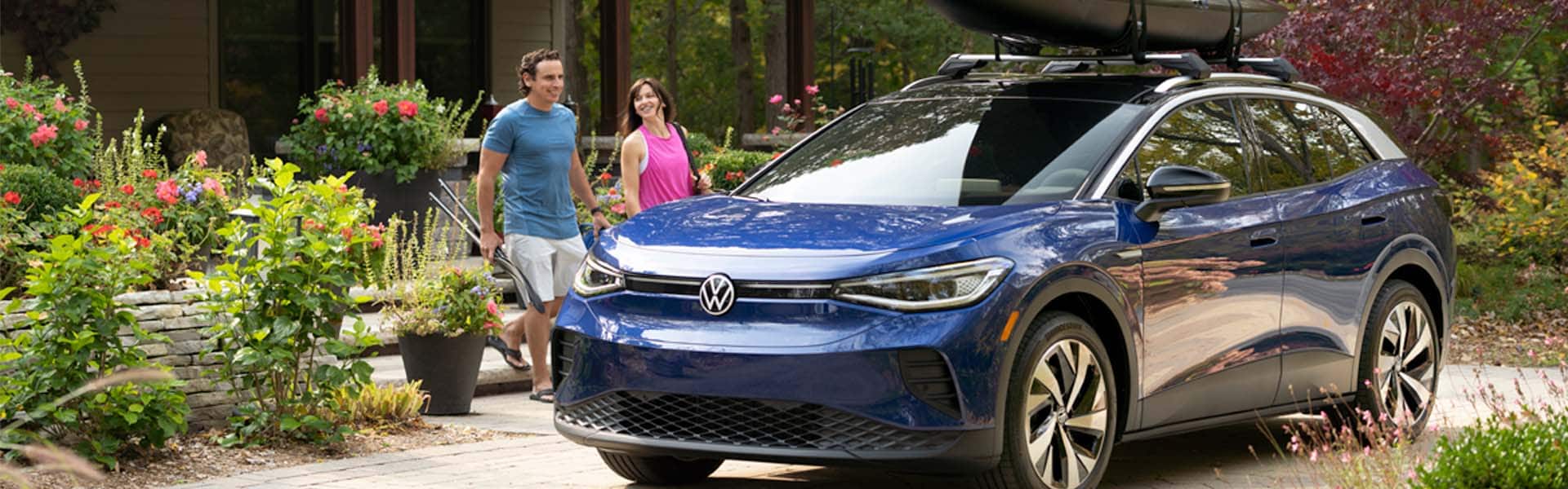 What is included in a Multi-Point Inspection? | West Broad Volkswagen in Richmond | Couple Walking Towards Blue Volkswagen ID4 Electric Vehicle