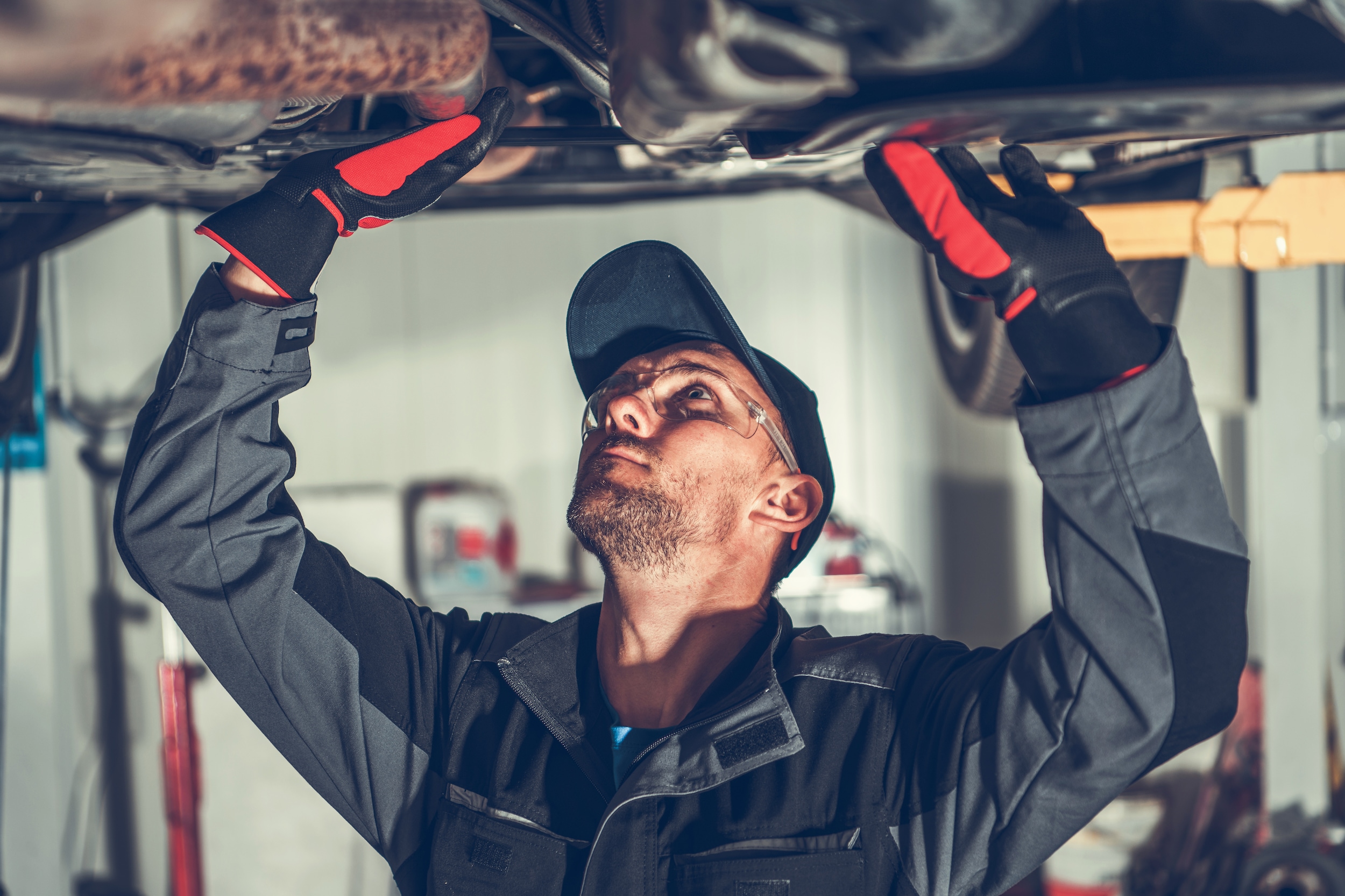 West Broad Volkswagen is a Volkswagen Dealership near Henrico, VA | Mechanic inspecting underside of vehicle