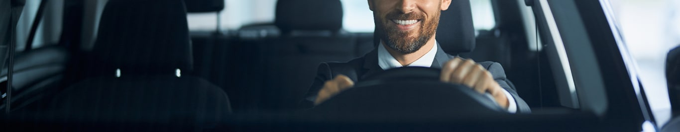 Enjoy A Test Drive At   West Broad VW in Richmond, VA | Man smiling while driving in his new car with black interior