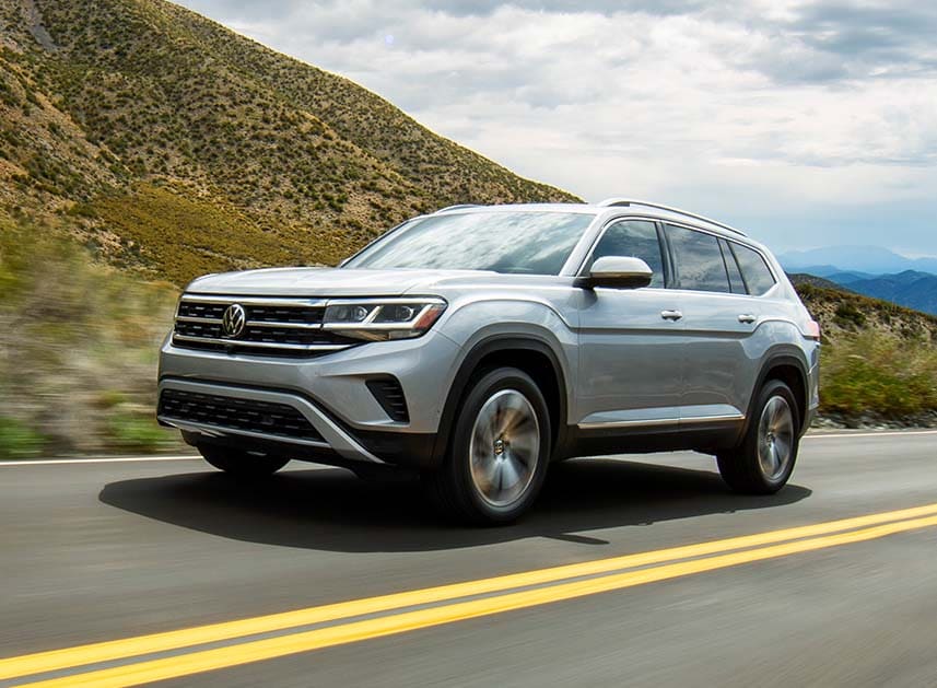 Compare the 2021 Volkswagen Atlas vs. the 2021 Ford Escape at West Broad Volkswagen | Silver 2021 Volkswagen Atlas Driving Past Lush Green Mountains