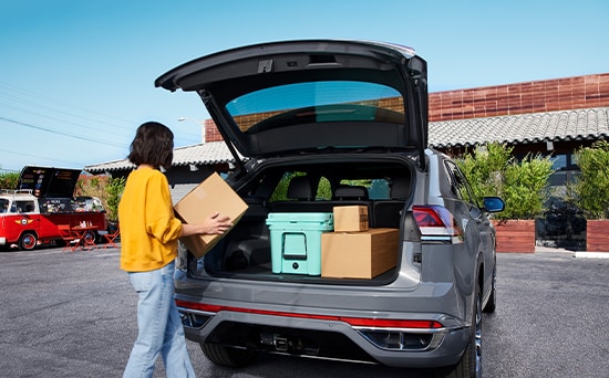Model Features of the 2021 Volkswagen Atlas Cross Sport at West Broad VW | Women uses trunk of Atlas Cross Sport for groceries