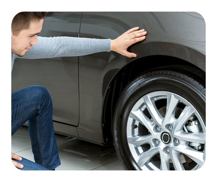 Tire Pressure Information at West Broad VW in Richmond, VA | Man leaning over to inspect the condition of his car tire 