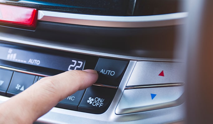 How to Get Your Car Summer Ready at West Broad VW in Richmond, VA | Person's finger going to touch the 'Auto' button for the climate control A/C