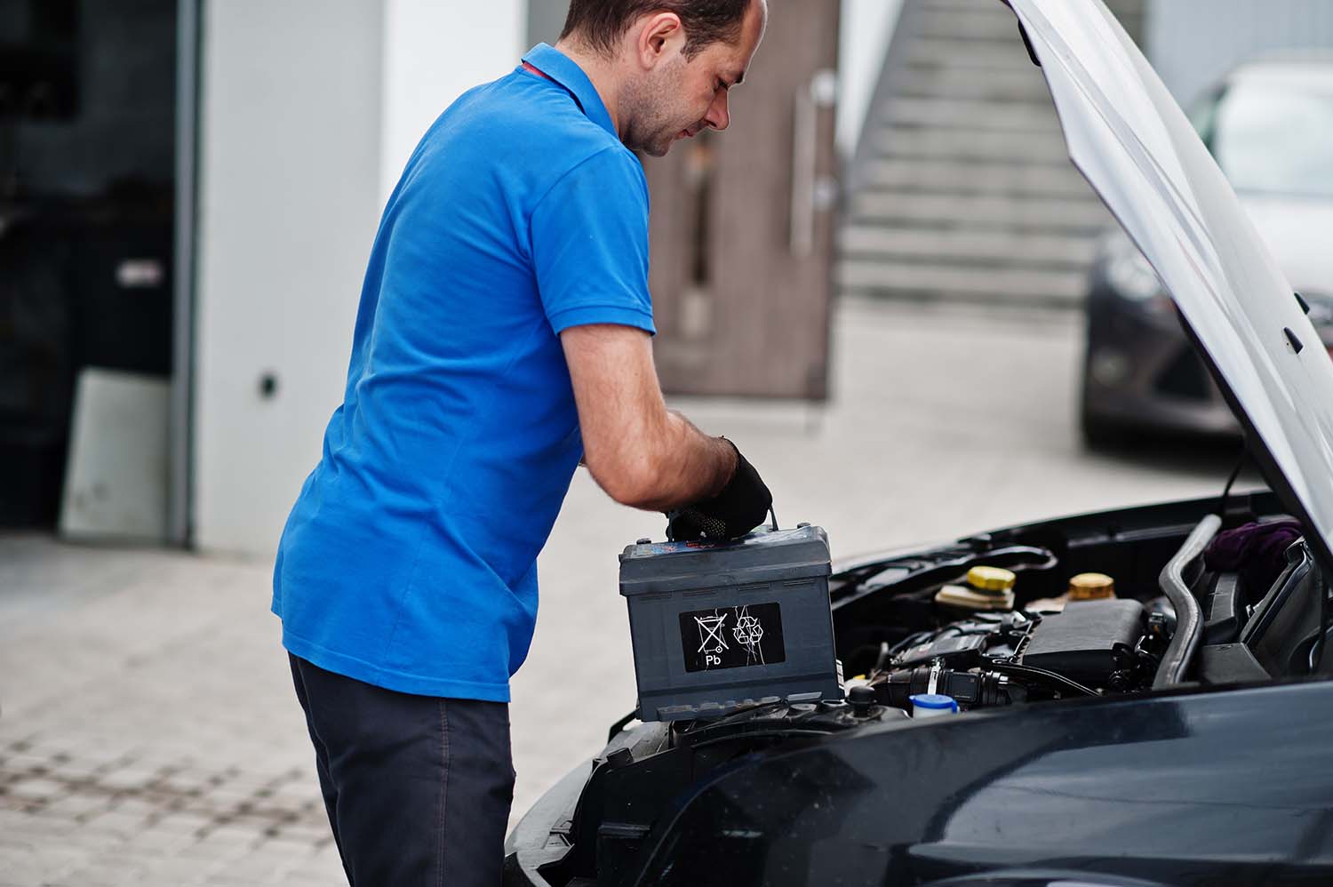 Everything You Need to Know about Your Car Battery at West Broad Volkswagen | Man putting new battery in his vehicle