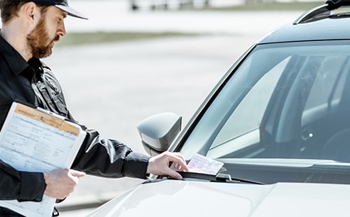 Why You Shouldn’t Drive Around with a Chipped Windshield at West Broad VW in Richmond, VA | Policeman putting a ticket on car windshield