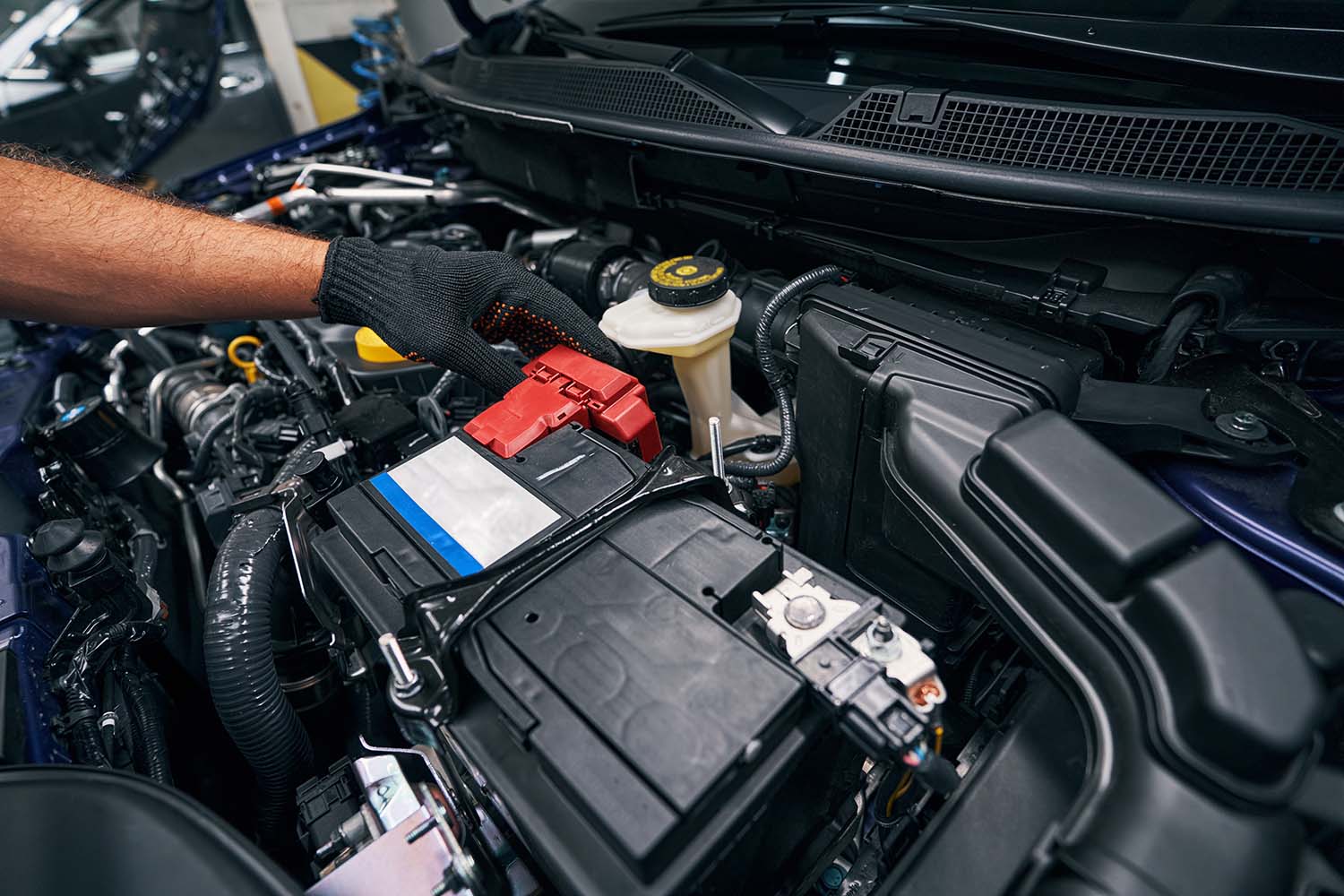 Everything You Need to Know about Your Car Battery at West Broad Volkswagen | Volkswagen service technician putting a new battery in a vehicle