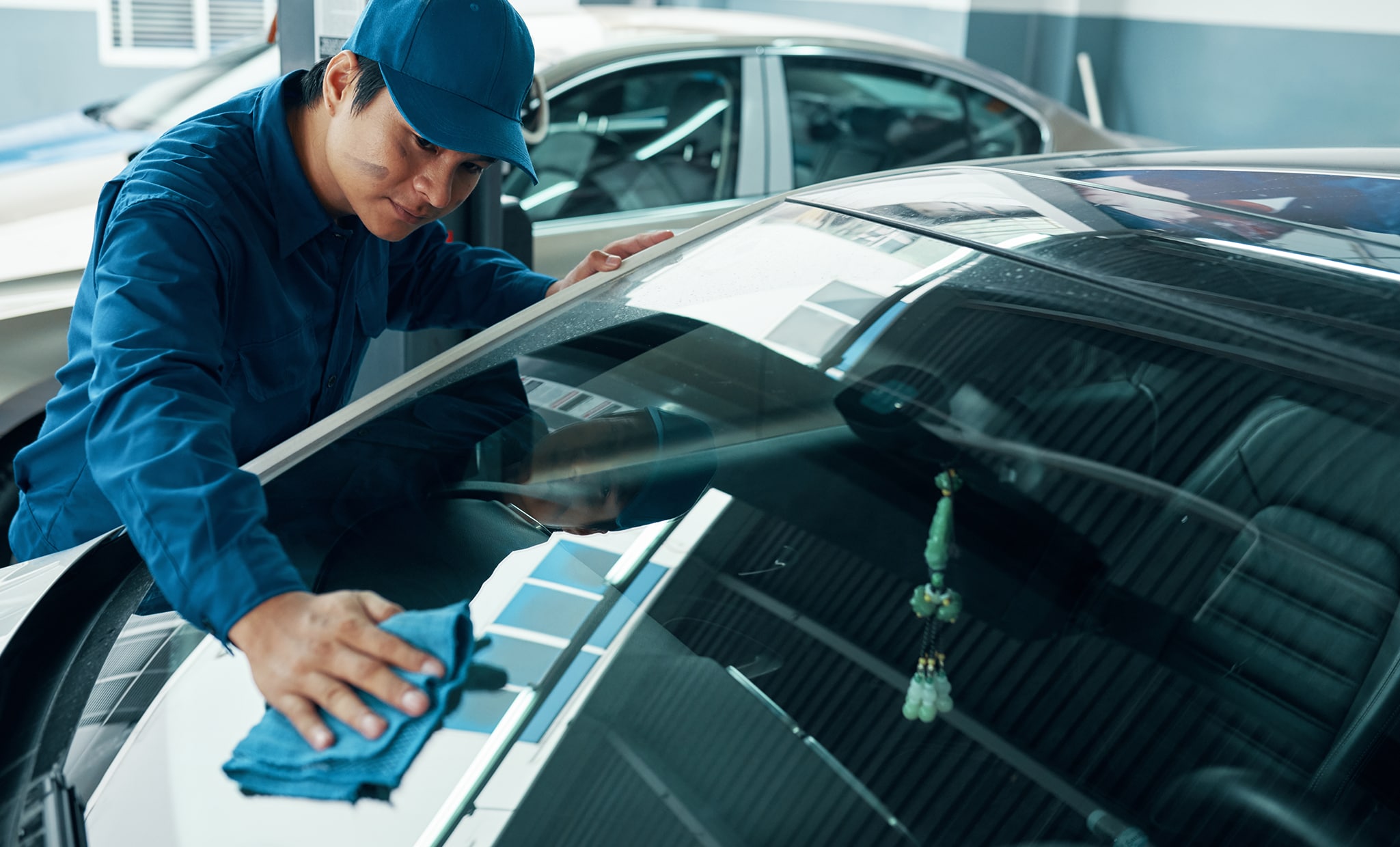 Why You Shouldn’t Drive Around with a Chipped Windshield at West Broad VW in Richmond, VA | Glass repair man wiping the top of car windshield