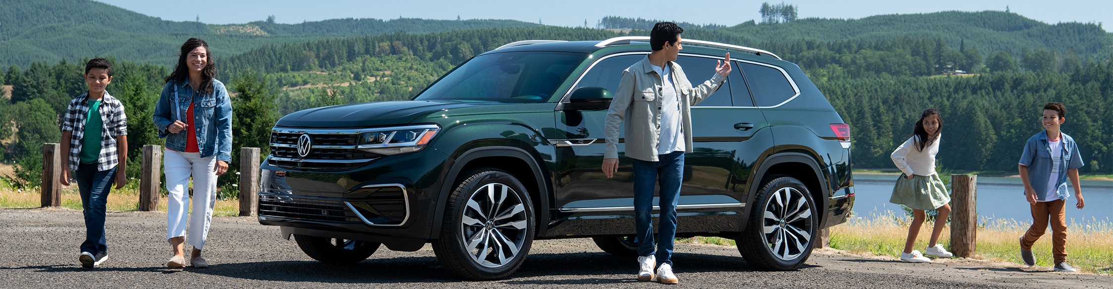 Model Features of the 2022 Volkswagen Atlas at West Broad Volkswagen | Dark green Volkswagen Atlas parked with a happy family walking beside it