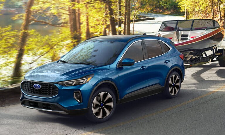 2023 Ford Escape towing a boat inside a forest