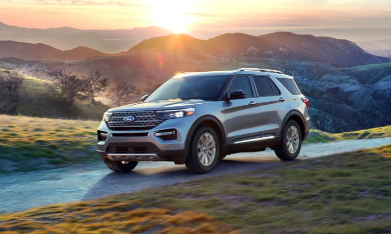 2021 Ford Explorer driving across grassy hills by mountain