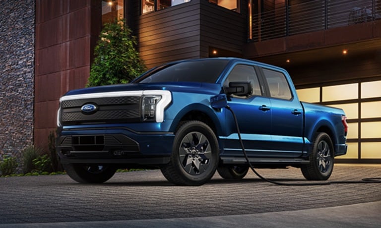 2023 Ford F-150 Lightning in blue exterior parked at home