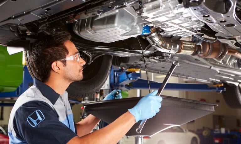 Honda Service Mechanic Under Car With Wrench