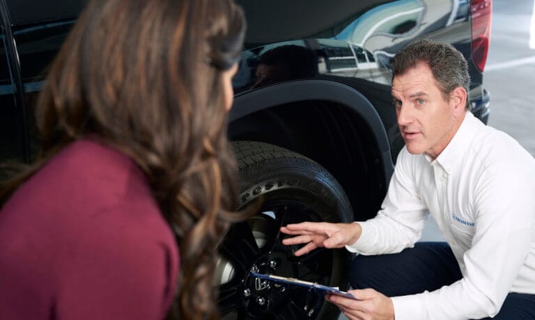 Honda Service Employee Checking Tire For Driver