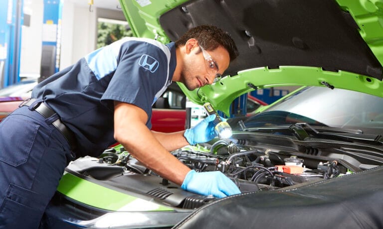 Honda-Service-MechanicCheckingUnderHoodWithFlashlight