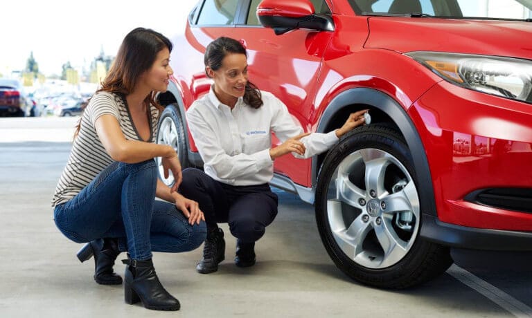 Honda technician showing driver tire