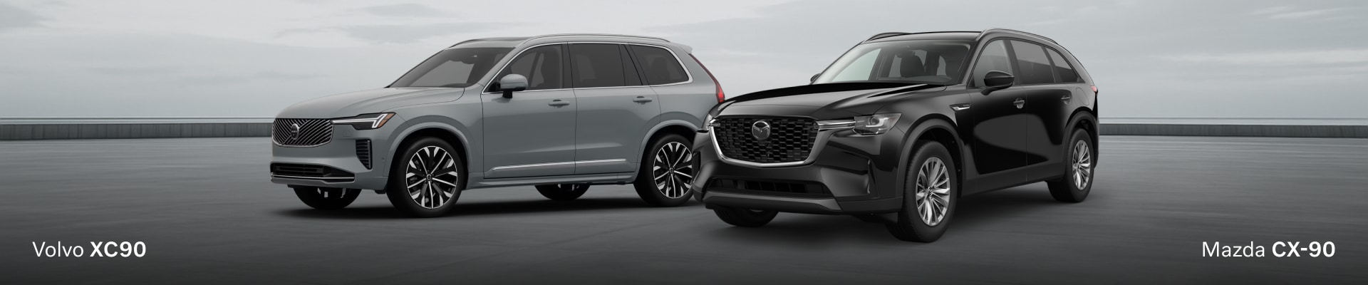 Two SUVs, the silver the 2026 Volvo XC90 and the 2026 Mazda CX-90, are parked on a grey surface under a cloudy sky.