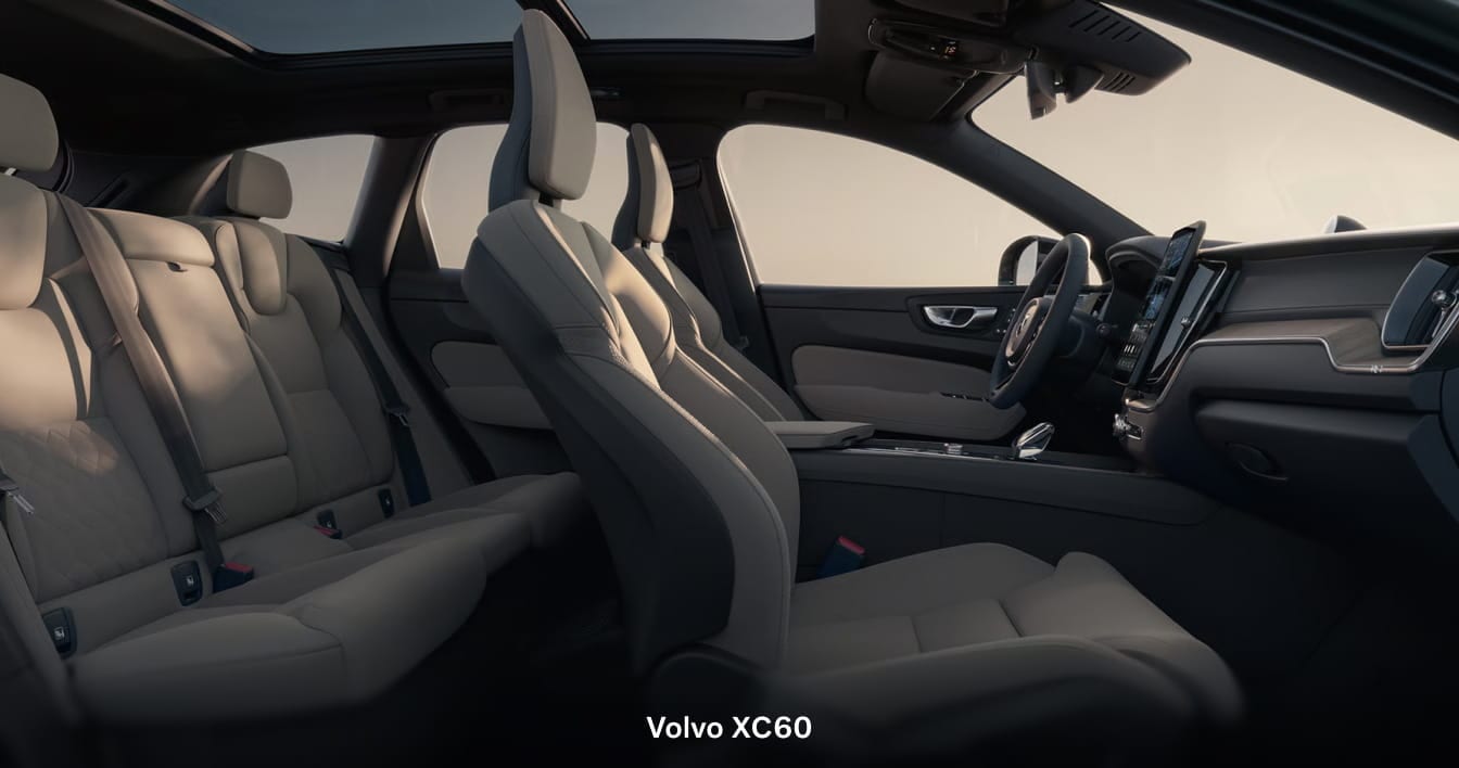 Volvo XC60 interior with light-colored seating, a panoramic roof, and a center touchscreen display.