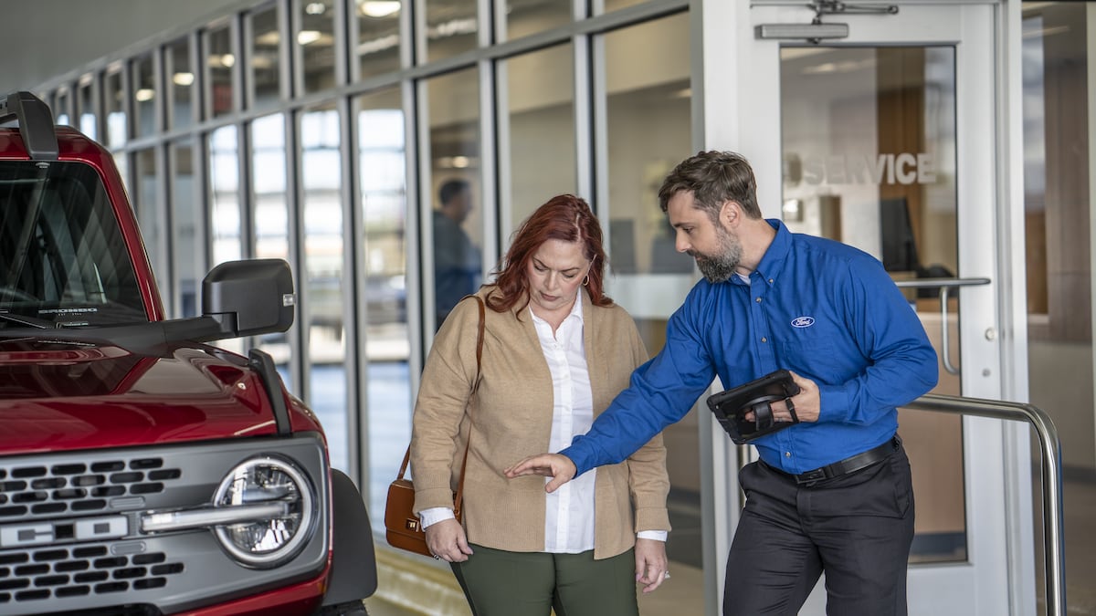 Ford service specialist walking a customer through her repair options