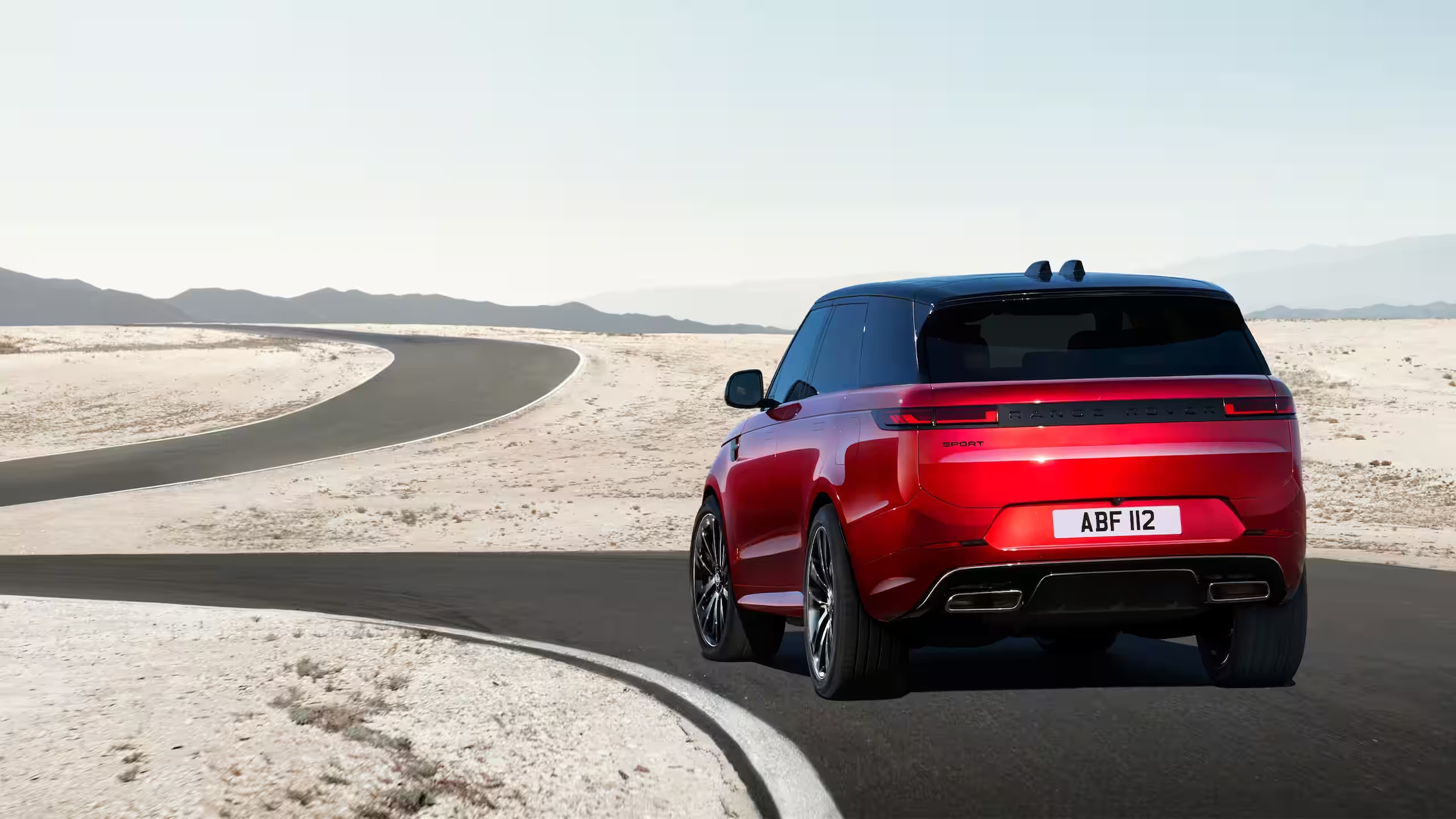 Red 2024 Range Rover Sport driving on a curvy road
