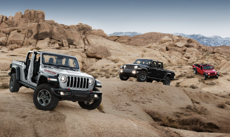 3 2023 Jeep Gladiators exterior offroad on desert rocks