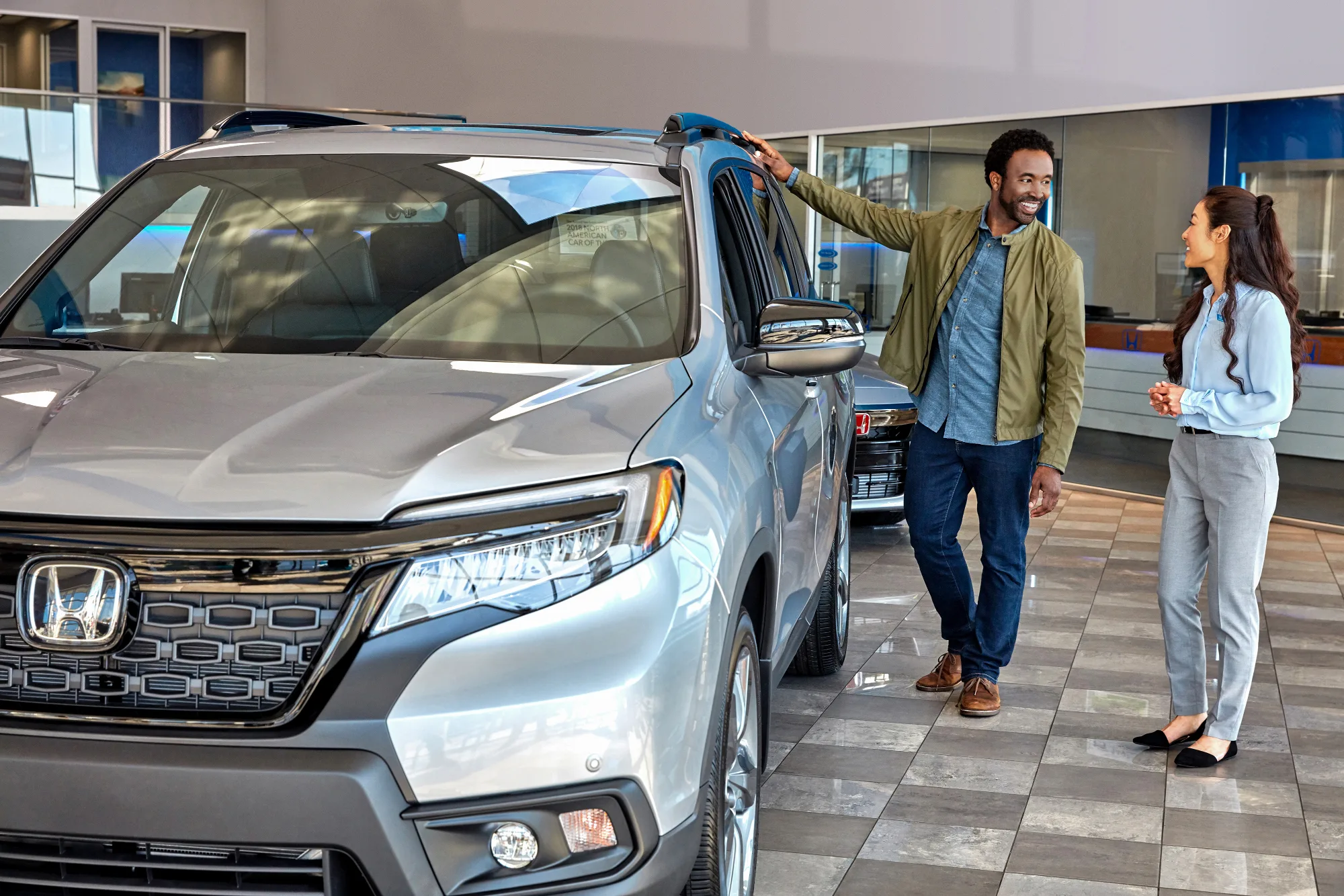 Man speaking to sales personal in car dealer