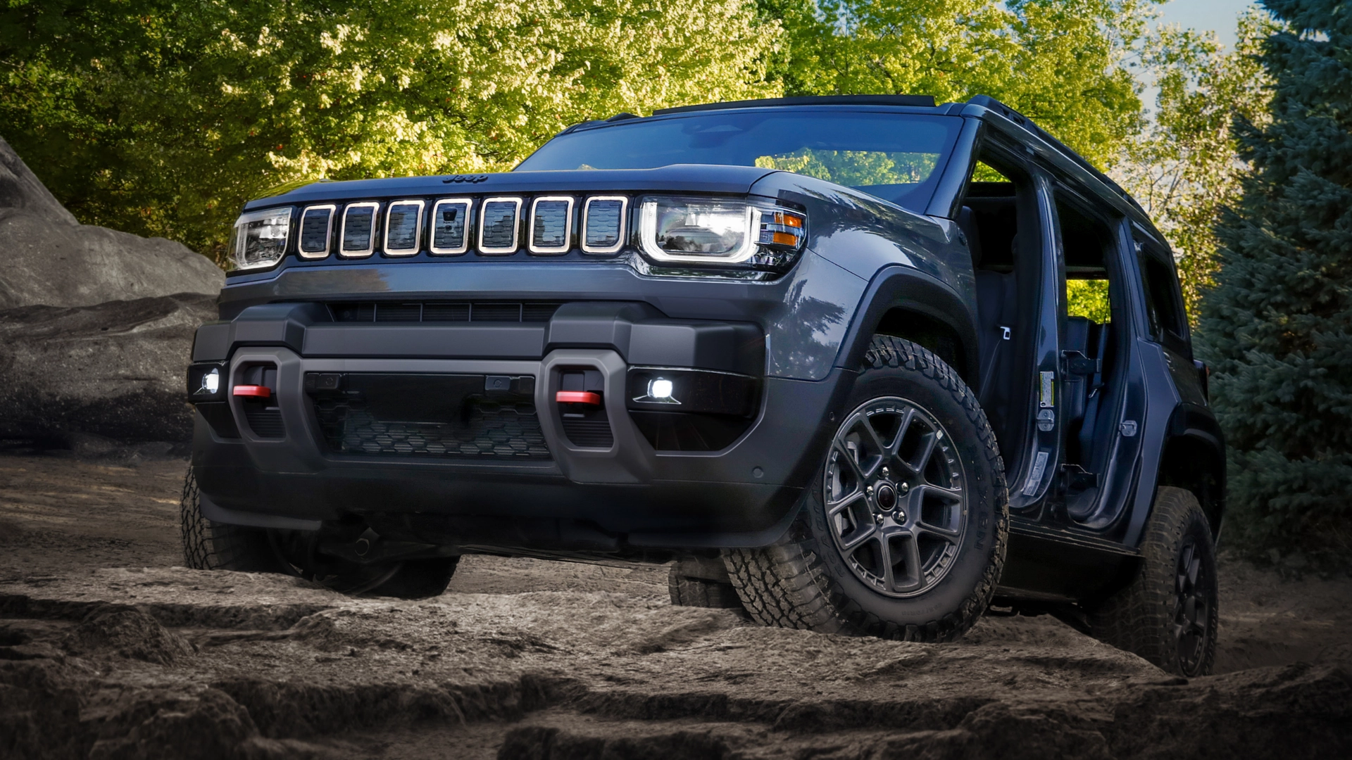 2026 Jeep® Recon blue off-road SUV climbing rocky trail with open doors and rugged all-terrain tires