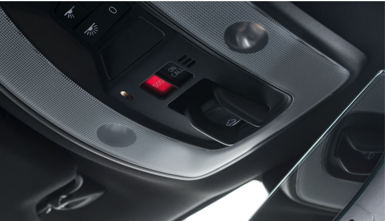 Close-up interior view of a Volvo XC60 overhead console showing the illuminated SOS button.