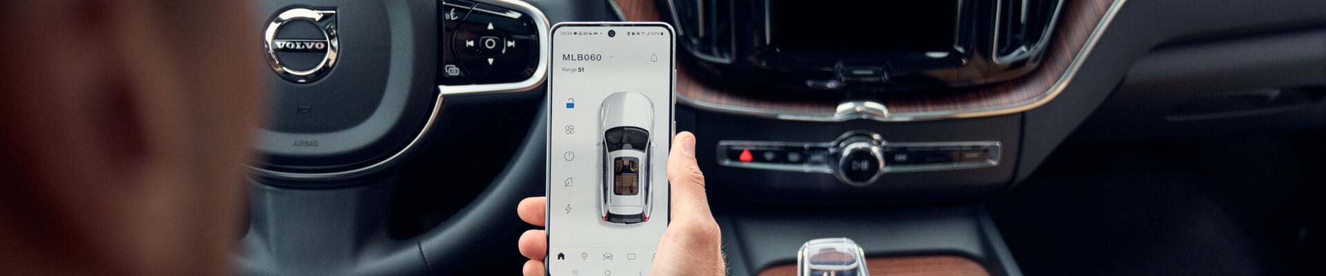 Interior view of a Volvo XC60 in Charcoal Nappa Leather highlighting the Volvo Cars mobile app inside the cabin.