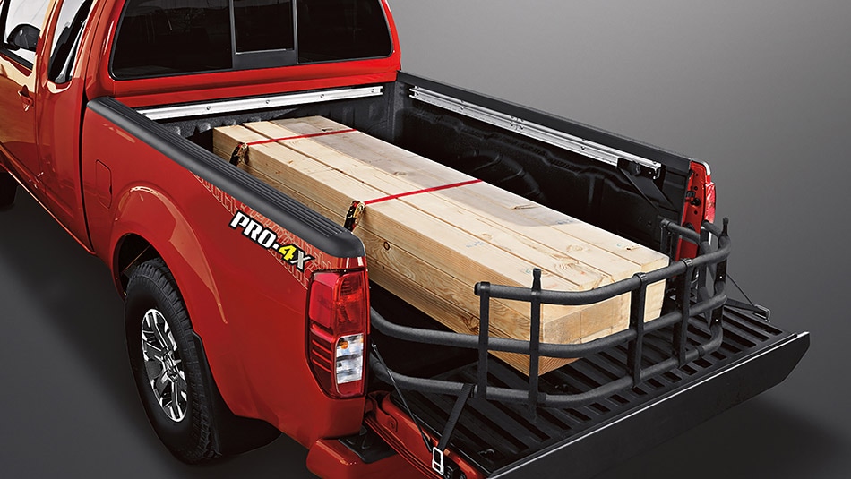 Red 2015 Nissan Frontier with Wood Planks Tied Down in Cargo Bed