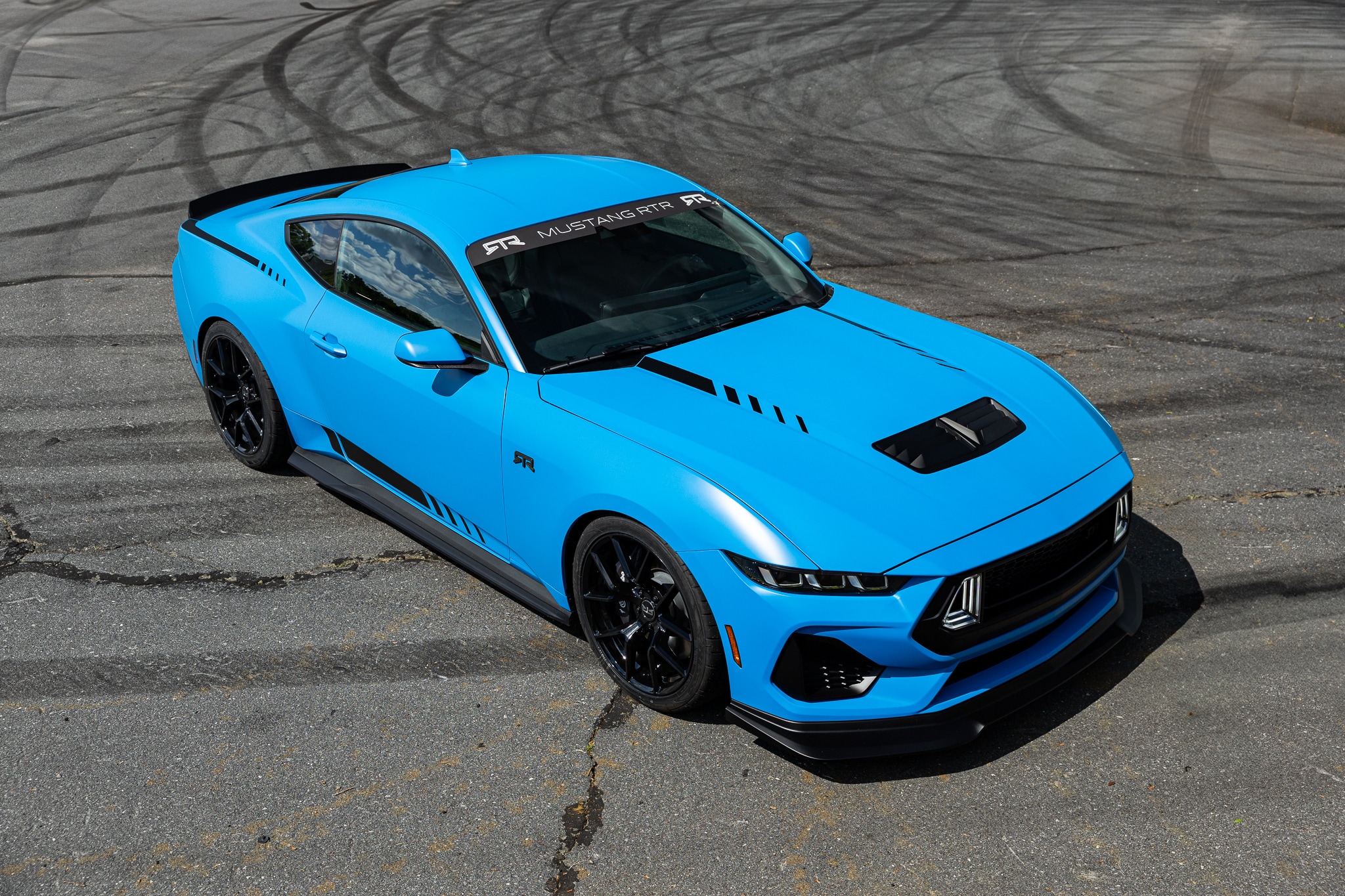 Bright blue Mustang RTR cornering on a racetrack in Utah
