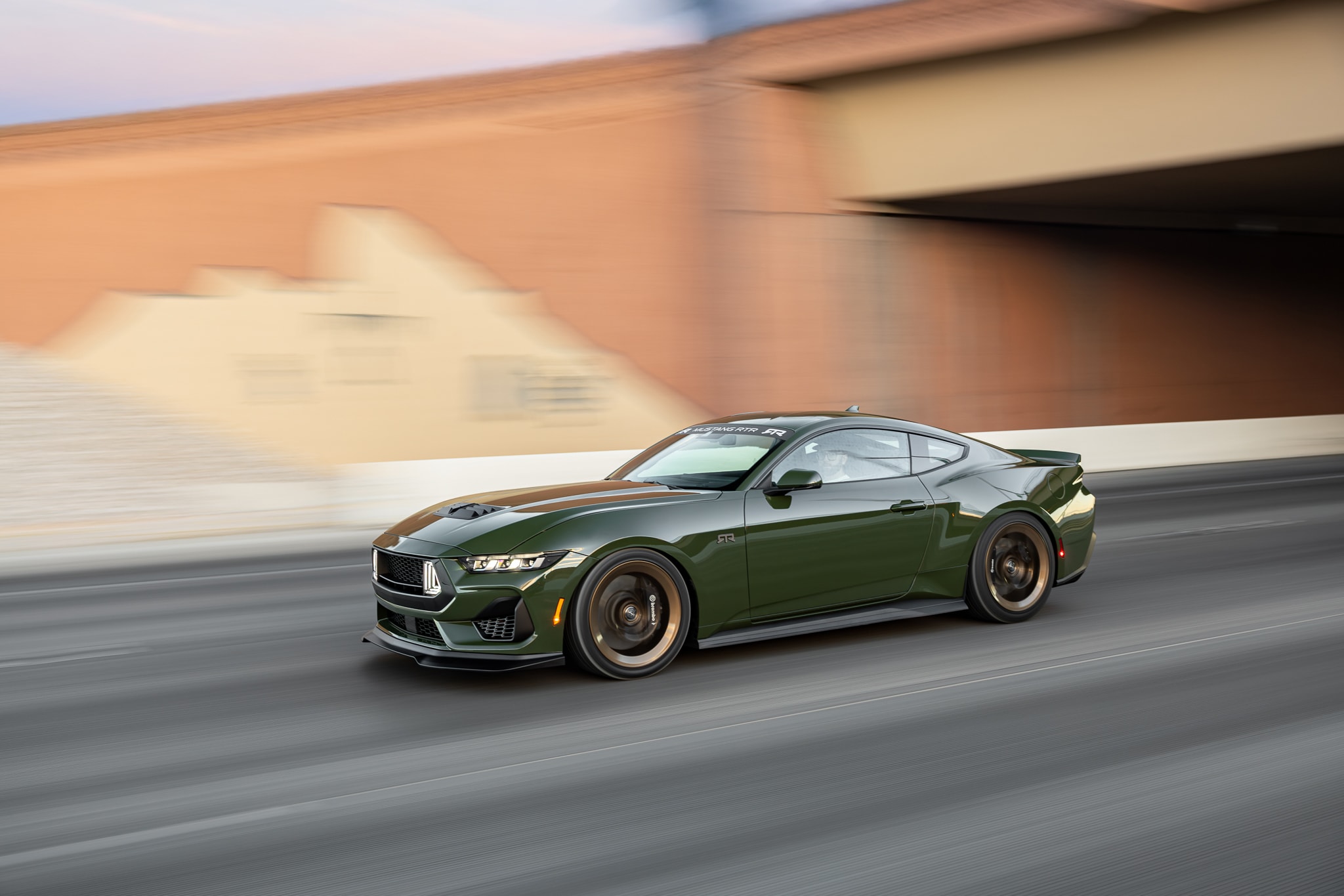 Green Mustang RTR driving under a bridge