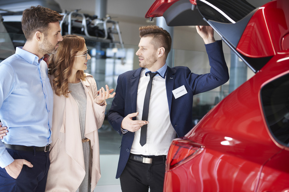 storyblocks-salesman-showing-couple-the-car-trunk_SPf6Tkt5f_PMNW.jpg