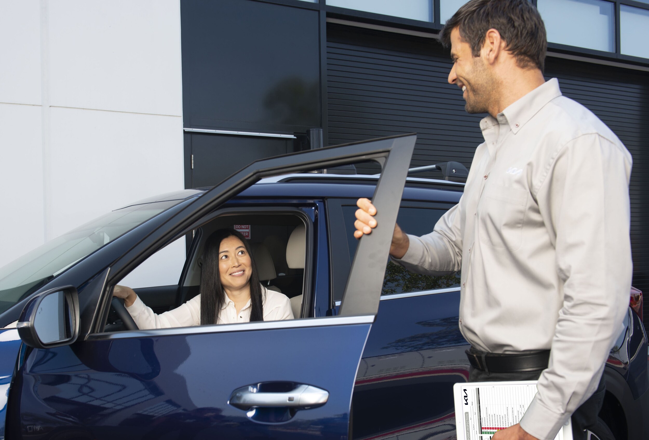  Kia representative talking to customer in vehicle
